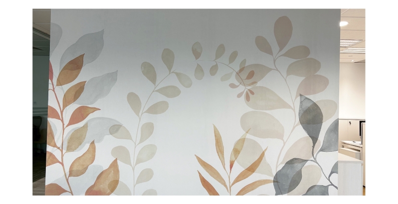  Completed botanical-themed wallpaper installation with soft pastel leaves in an office setting